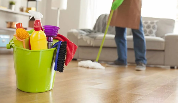 Professional cleaners mopping a home floor with a supply bucket